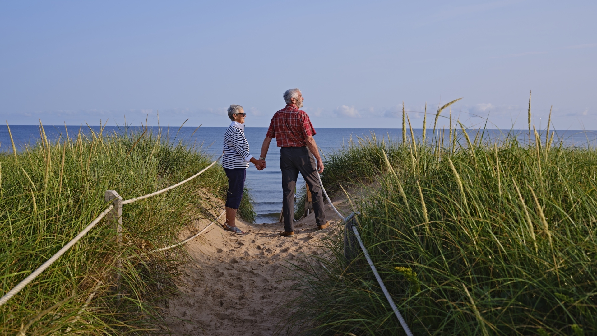 Older couple holding hands along the beach